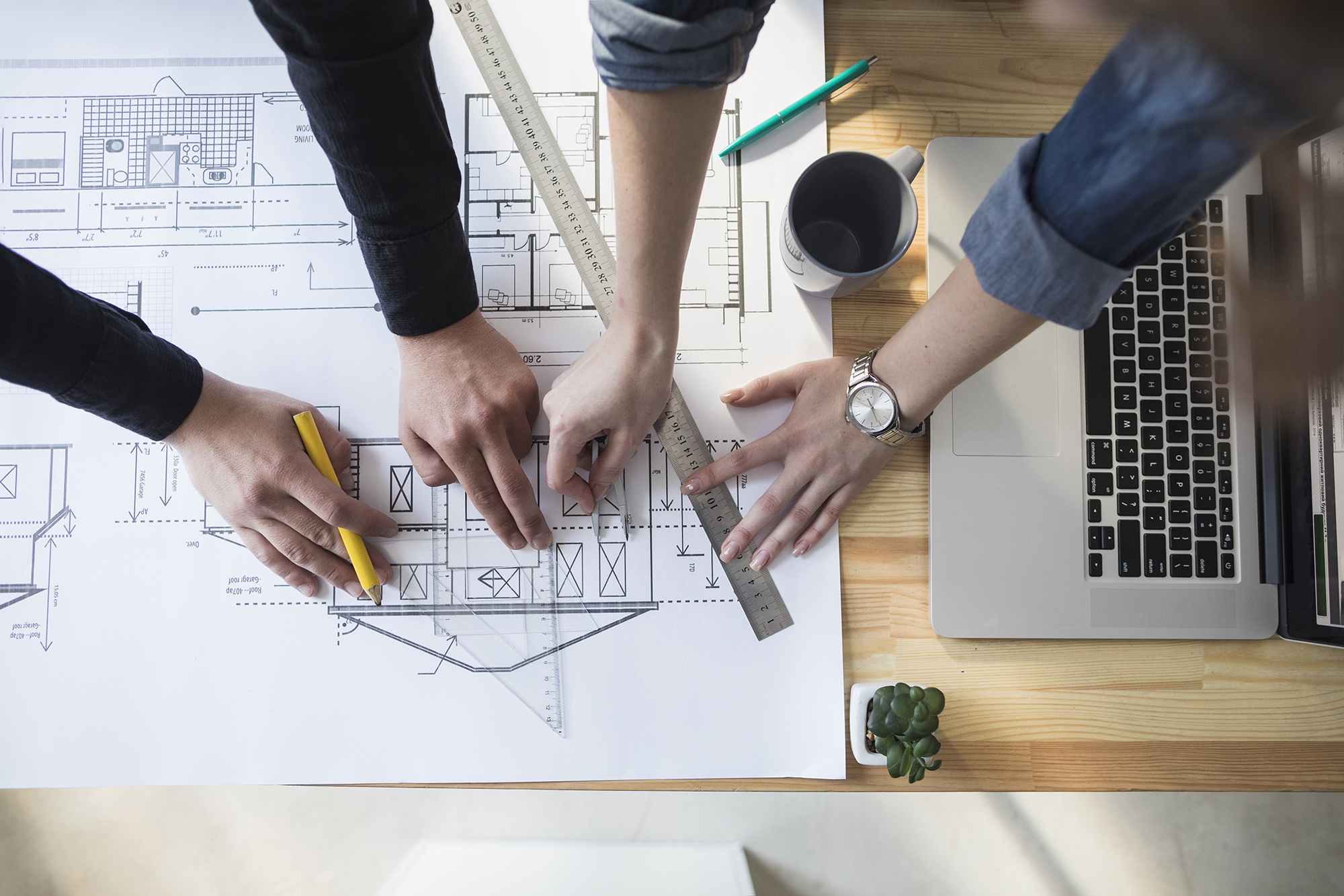 high-angle-view-worker-s-hand-working-blueprint-wooden-table-workplace